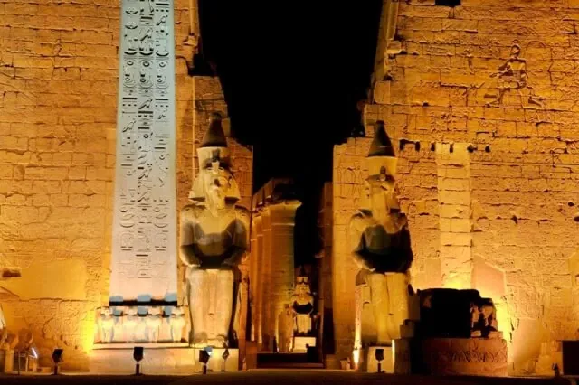 Luxor Temple illuminated at night Egypt 2026 — obelisk and First Pylon of Ramesses II lit in gold against the night sky