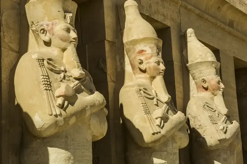 Temple of Hatshepsut colonnade detail Luxor Egypt — Hathor-head columns and osirid statues of Hatshepsut in royal regalia
