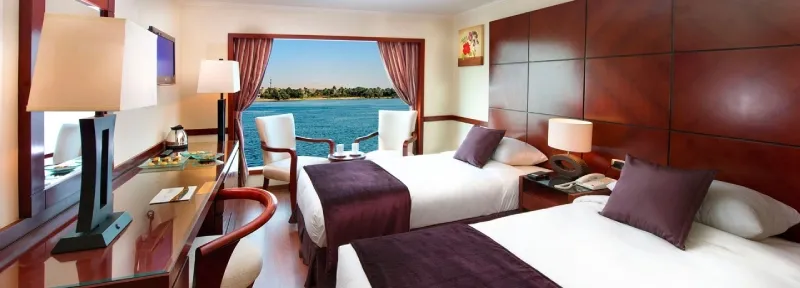 Amwaj Livingstone standard twin cabin — panoramic Nile-view window, full-size bathtub, 43-inch LCD TV, free WiFi, mini bar, 5-star classic Nile cruise Egypt 2026