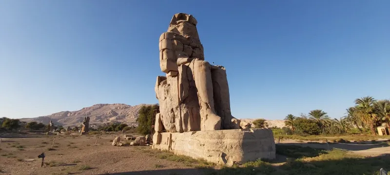 Colossi of Memnon north statue face close-up Luxor Egypt — weathered quartzite Amenhotep III the singing colossus