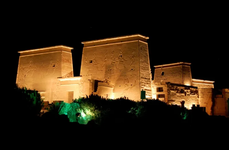 Philae Temple Sound and Light Show Aswan Egypt night — illuminated columns and Kiosk of Trajan reflected in reservoir water