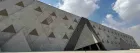 Grand Egyptian Museum GEM exterior at night with Pyramids of Giza visible behind Giza Egypt 2026